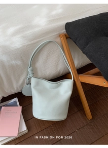 Close-up of light blue lychee pattern leather bucket bag with elegant knot detail