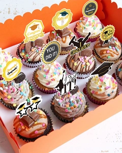 Vista dall'alto di topper per cupcake di laurea con tocchi e medaglie in una scatola