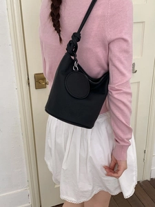 Minimalist black bucket shoulder bag with knotted strap and silver hardware for women