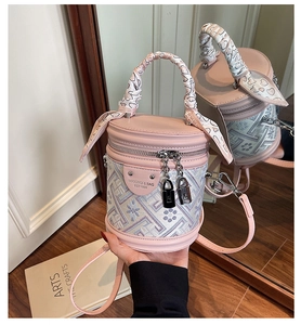 Détail du sac seau rose clair avec broderie florale et anse en foulard de soie
