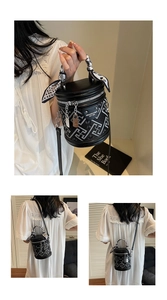 Détail du sac seau noir avec broderie géométrique et foulard en soie sur la poignée