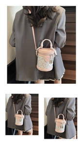 Détail d'un sac seau rose et blanc avec poignée tissée et décoration de serrure en métal