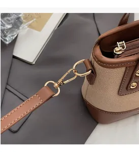 Détail de la garniture dorée et du cuir sur un sac seau vintage beige élégant