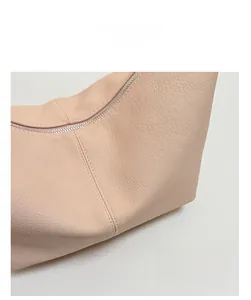 Close-up of pink soft leather texture and silver metal zipper on the shoulder bag
