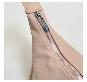 Detailed macro view of the textured leather bag featuring a robust solid metal zipper