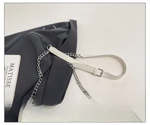 Détail d'un sac en cuir grainé blanc crème avec chaîne argentée et bandoulière réglable
