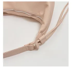 Macro shot of adjustable leather shoulder strap and silver hardware on a crossbody bag