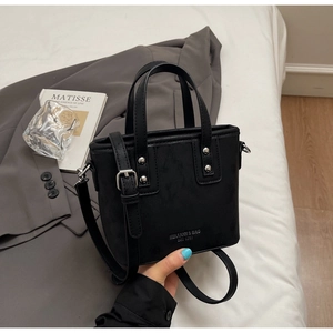 Dettaglio mini borsa nera opaca con borchie argentate e tracolla regolabile
