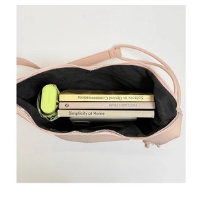 Internal view of a nude pink shoulder bag showing capacity for books, umbrella and phone