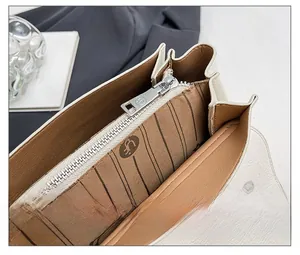 Détail du zip argenté fluide et de la doublure logo sur le sac crème chic