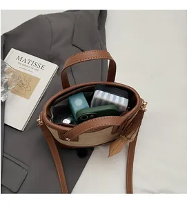 Détail de l'intérieur spacieux de ce sac seau bicolore contenant des objets du quotidien