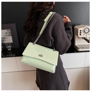 Détail du sac bandoulière vert menthe avec fermoir rotatif argenté et chaîne chic