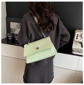 Détail du sac bandoulière vert menthe avec boucle en métal argenté et chaîne en cuir