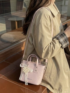 Borsa a secchiello in pelle rosa con ciondolo a cuore e fiocco in pizzo bianco