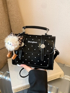 Chic black patent leather polka dot handbag with fluffy monster charm for daily commute