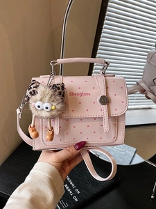 Pink polka dot handbag for women with cute plush charm and adjustable shoulder strap