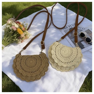 Detail of hand-woven straw saddle bags in khaki and beige on a summer picnic blanket