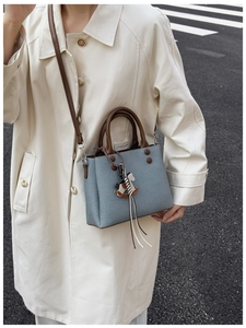 Blue-gray textured small square bag with leather handle and cute wooden horse charm detail