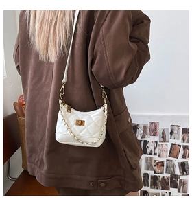 Weiße gesteppte Mini-Eimertasche mit Goldkette und Drehverschluss auf einer Rückansicht