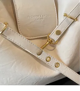Dettaglio della borsa in pelle bianco crema con ganci dorati e grana fine
