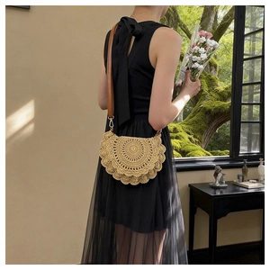 Detail of handmade hollow straw shoulder bag with woven texture and leather strap