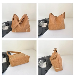 Dettaglio della borsa tote con borchie, trama in pelle marrone e finiture metalliche