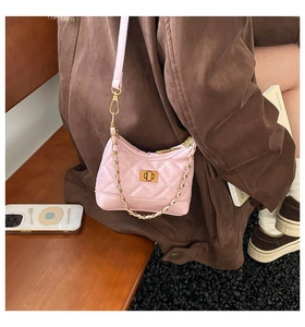 Detailansicht der rosa gesteppten Ledertasche mit Goldschloss und gewebtem Kettenriemen