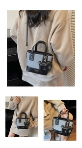 Détails du sac seau bicolore en toile bleue et cuir noir avec breloque chien