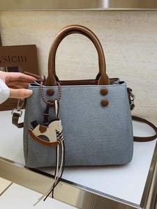 Light blue denim texture handbag with brown leather straps and rocking horse charm