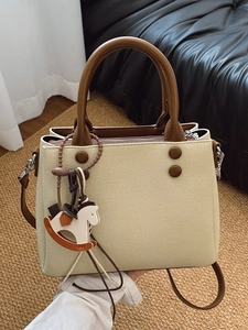 Beige saffiano faux leather handbag with brown straps and a cute rocking horse charm