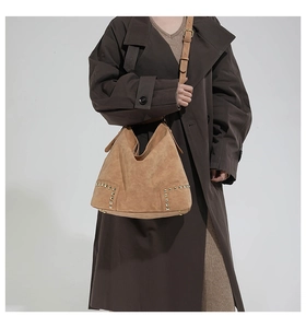 Dettaglio di borsa tote vintage in pelle scamosciata cammello con borchie dorate