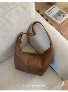 Detail of soft dark brown pebble leather shoulder bag with unique knotted strap design