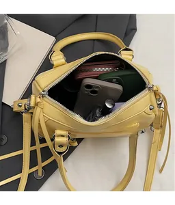 Top view of yellow rivet handbag interior showing storage capacity for phones and wallet
