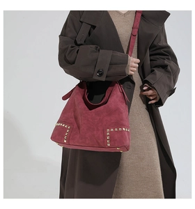 Dettaglio borsa hobo bordeaux con borchie dorate vintage e trama effetto scamosciato