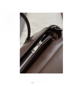 Macro shot of silver metal zipper closure and dark brown leather texture of the handbag