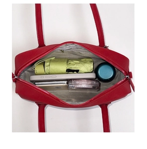 Top view of red baguette bag showing spacious interior with daily essentials and umbrella