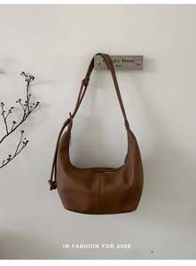 Detail of soft brown leather hobo bag with vertical stitching and adjustable strap