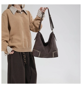 Dettaglio borsa shopper vintage marrone con rivetti dorati e texture in pelle opaca