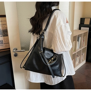 Détail d'un grand sac cabas en cuir noir avec boucle dorée et logo texte de mode