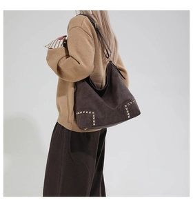 Dettaglio di borsa tote vintage in pelle scamosciata marrone con borchie quadrate dorate