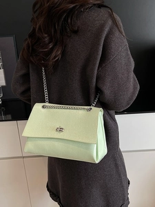 Sac à bandoulière vert clair brillant avec chaîne et fermoir rotatif argenté épuré