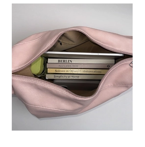 Detailed interior of pink shoulder bag showing spacious storage with zipper pocket