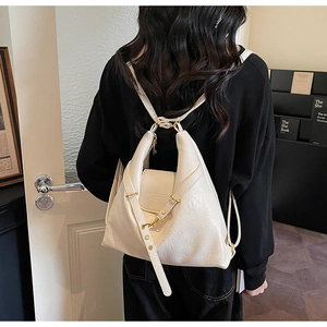 Détail d'un sac à dos en cuir blanc plissé avec boucle dorée et étiquette de mode
