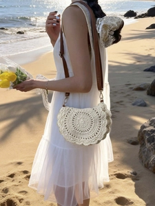 Handmade cream crochet saddle bag with hollow patterns and adjustable brown leather strap