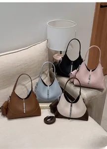 Various colors of leather dumpling bags with silver buckles shown on a sofa
