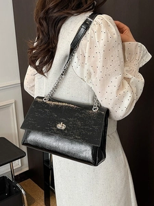 Sac à bandoulière noir brillant avec chaîne et serrure métallique pour la mode printemps 2026