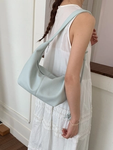 Minimalist soft leather hobo bag in light blue with wide shoulder strap and litchi texture