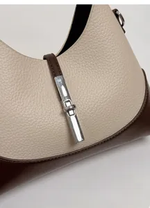 Detailed macro view of beige lychee texture leather and fine stitching on the handbag