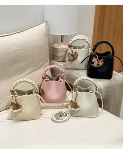 Close-up of woven leather handles and wooden rocking horse charms on bucket bags
