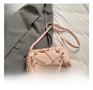 Detail showing pink glossy crossbody bag with metallic rivets and long fringe tassel accents